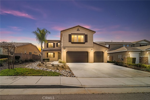 mediterranean / spanish house featuring fence, driveway, an attached garage, stucco siding, and a tiled roof