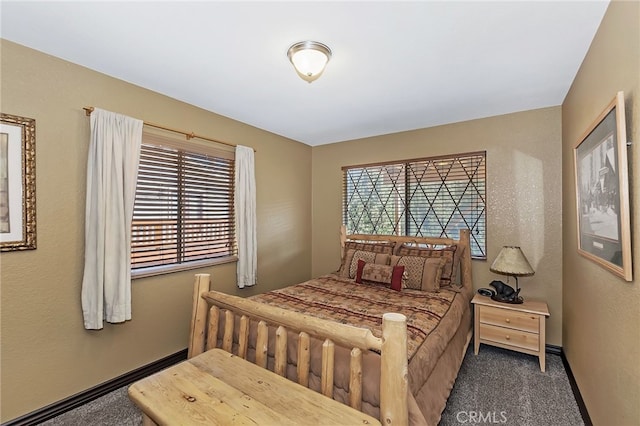 bedroom with baseboards, carpet, and a textured wall