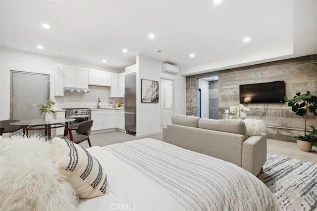 bedroom with connected bathroom, an accent wall, recessed lighting, a wall mounted AC, and a sink