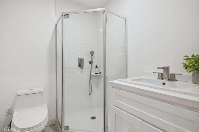 bathroom featuring a sink, toilet, and a stall shower