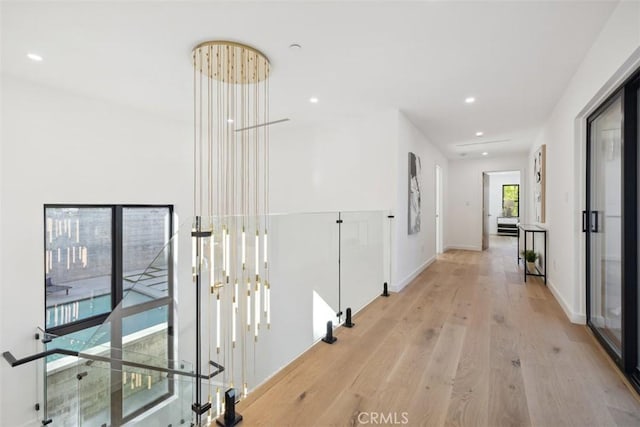 hallway with recessed lighting, light wood-style flooring, and baseboards