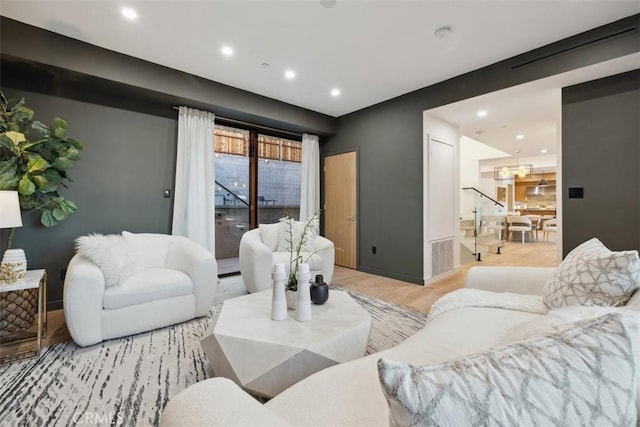 living area featuring a notable chandelier, recessed lighting, light wood-type flooring, and baseboards