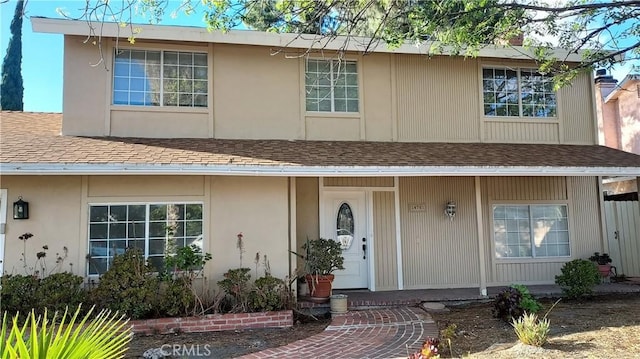 view of front of property featuring a shingled roof and stucco siding