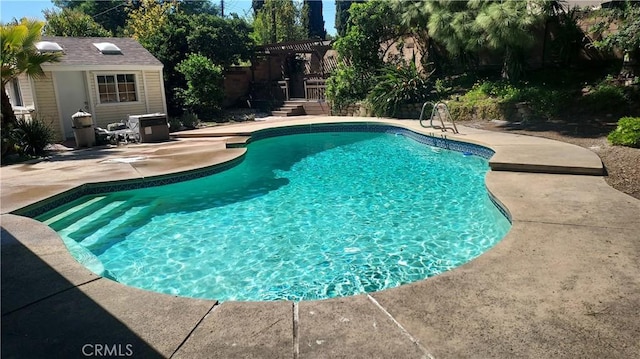 outdoor pool featuring an outdoor structure and a patio area