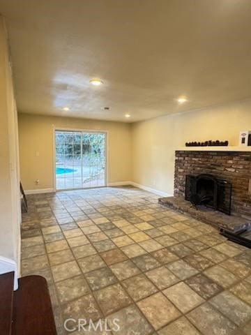 unfurnished living room with baseboards, a fireplace, and recessed lighting