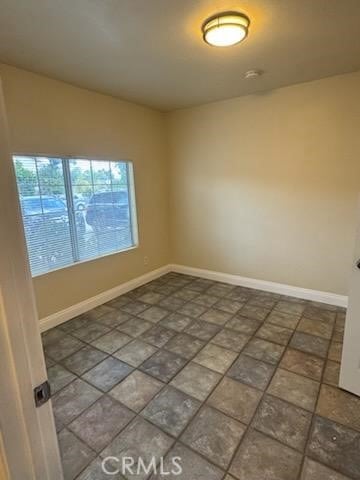 unfurnished room featuring baseboards