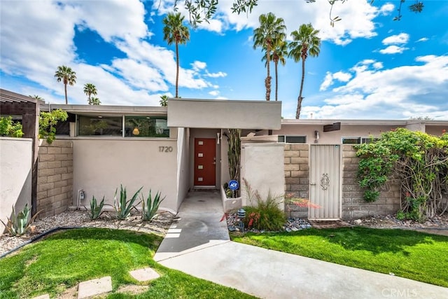 view of front of house featuring a gate, a fenced front yard, and stucco siding