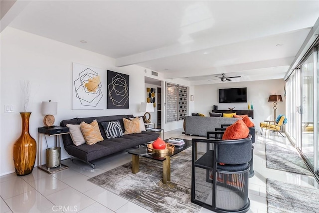 living room featuring beamed ceiling, light tile patterned flooring, and a ceiling fan