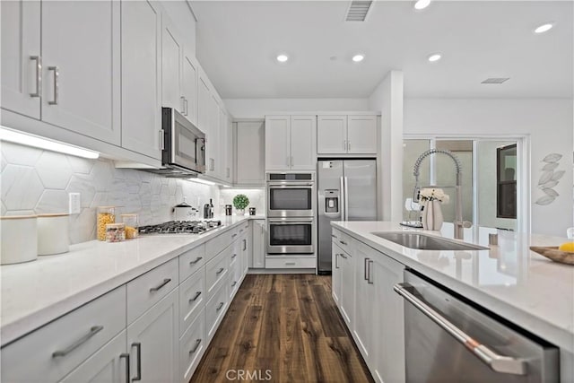 392 Baluster, Irvine, CA 92618 - kitchen featuring visible vents, dark wood finished floors, stainless steel appliances, white cabinetry, and a sink