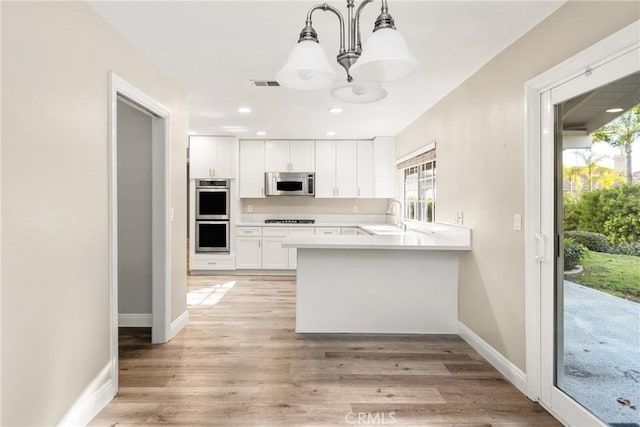 kitchen featuring visible vents, light wood-style flooring, light countertops, appliances with stainless steel finishes, and white cabinetry