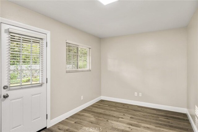 spare room with wood finished floors and baseboards