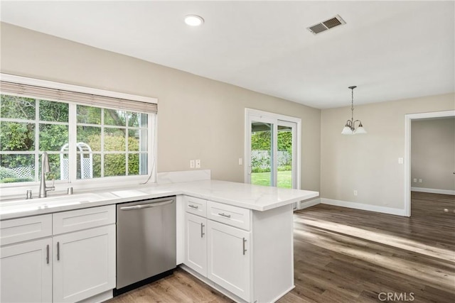 kitchen with visible vents, a sink, white cabinetry, a peninsula, and dishwasher