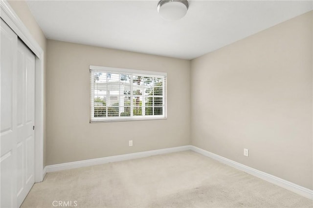 unfurnished bedroom featuring a closet, baseboards, and carpet floors