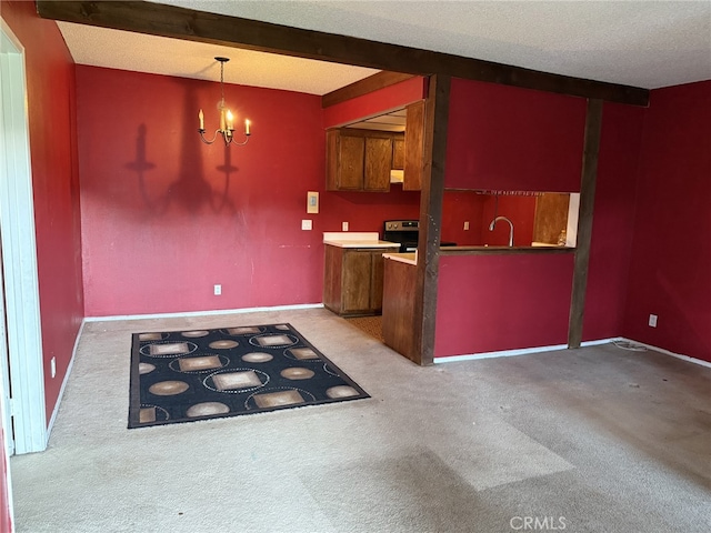 kitchen with a sink, electric range, light carpet, and a chandelier