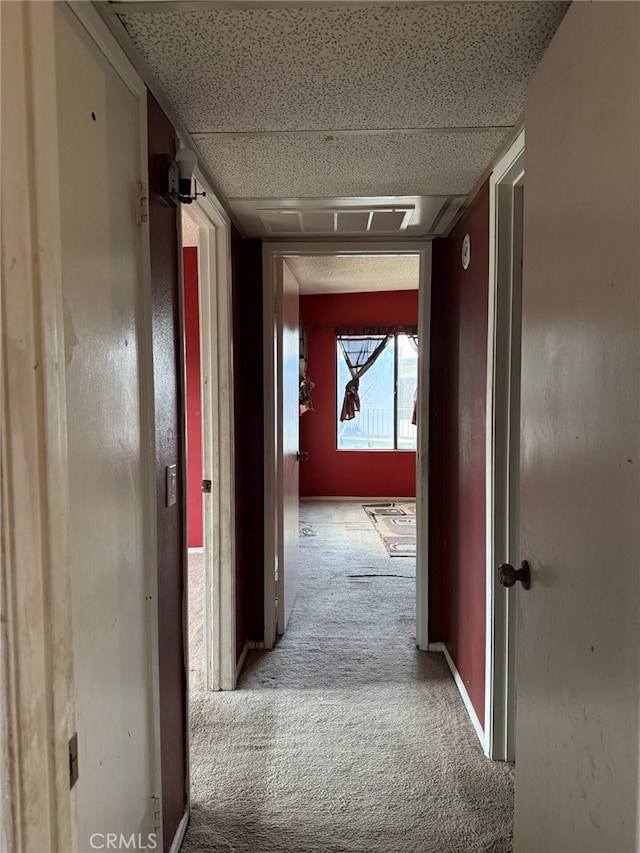 hall featuring baseboards and carpet floors