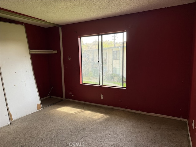 unfurnished bedroom featuring a closet, carpet floors, and a textured ceiling