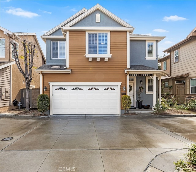 traditional-style house with stucco siding, driveway, and an attached garage