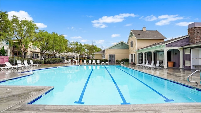 community pool featuring a patio and fence