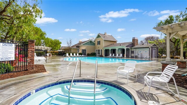 pool featuring a patio area, fence, a pergola, and a hot tub