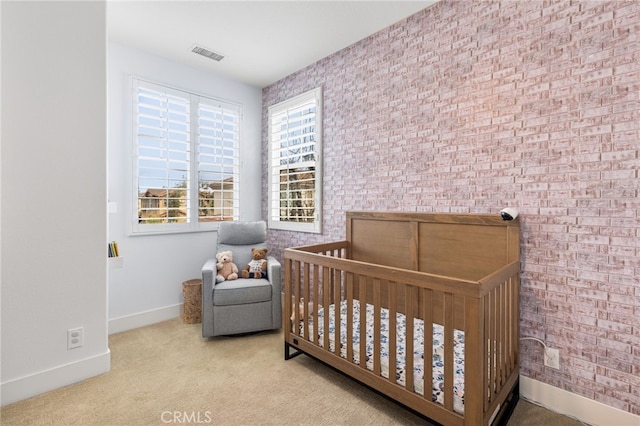 bedroom featuring visible vents, carpet floors, baseboards, and a crib