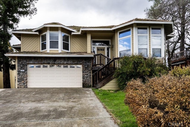 view of front of house with a garage, stone siding, and driveway