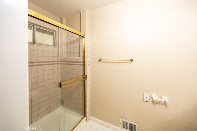 full bathroom featuring baseboards, visible vents, and a tile shower