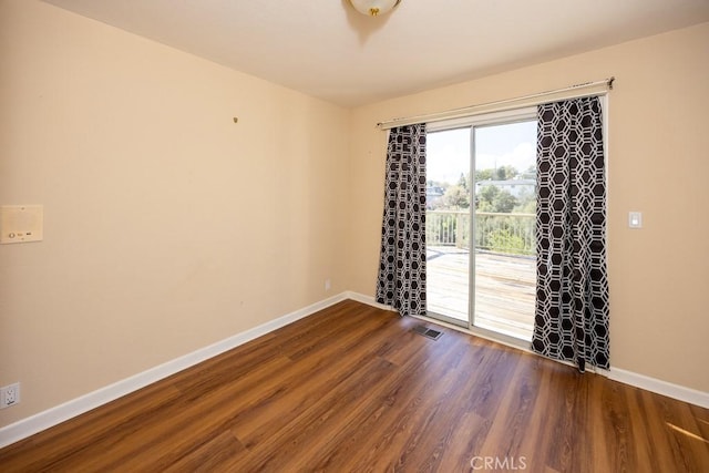 empty room with visible vents, baseboards, and wood finished floors