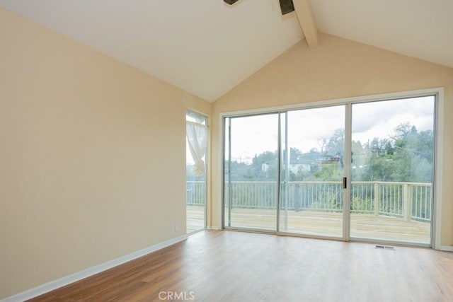 empty room featuring visible vents, a ceiling fan, wood finished floors, baseboards, and vaulted ceiling with beams