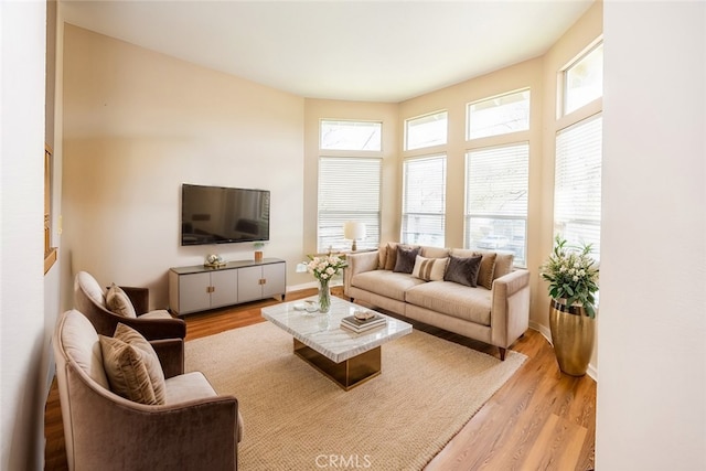 living area featuring light wood-type flooring and baseboards