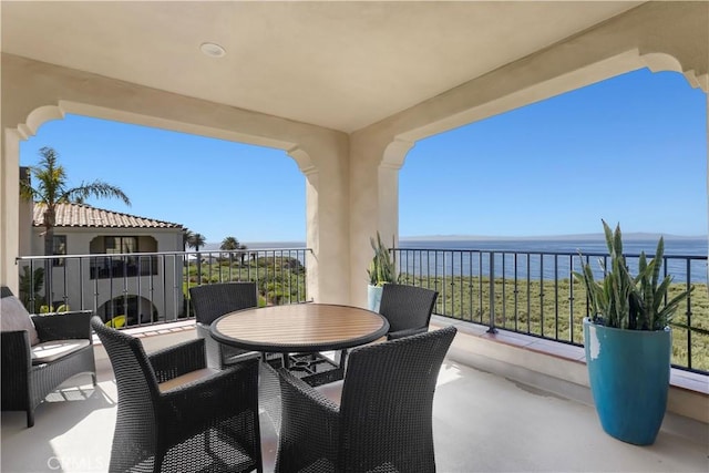 view of patio / terrace with a balcony and a water view