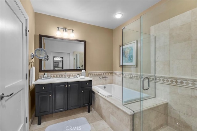 bathroom with vanity, a shower stall, a garden tub, and tile patterned floors