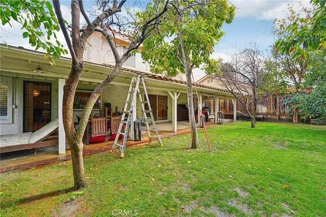 exterior space featuring a patio, a yard, fence, and stucco siding