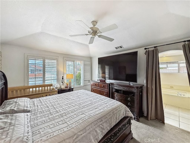 bedroom featuring visible vents, light colored carpet, a textured ceiling, and ceiling fan