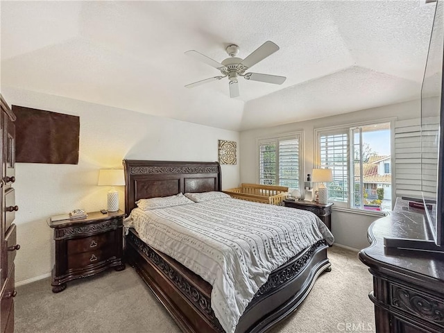 carpeted bedroom featuring a textured ceiling, a ceiling fan, baseboards, and vaulted ceiling