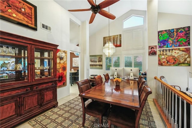 dining space featuring visible vents, light tile patterned floors, ceiling fan with notable chandelier, plenty of natural light, and high vaulted ceiling