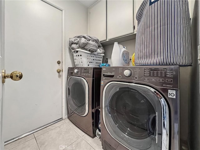 laundry room featuring light tile patterned flooring, cabinet space, and separate washer and dryer