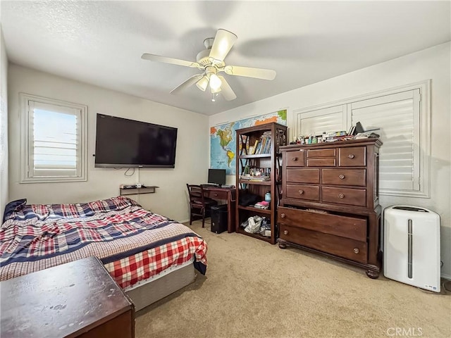 bedroom with light carpet and a ceiling fan