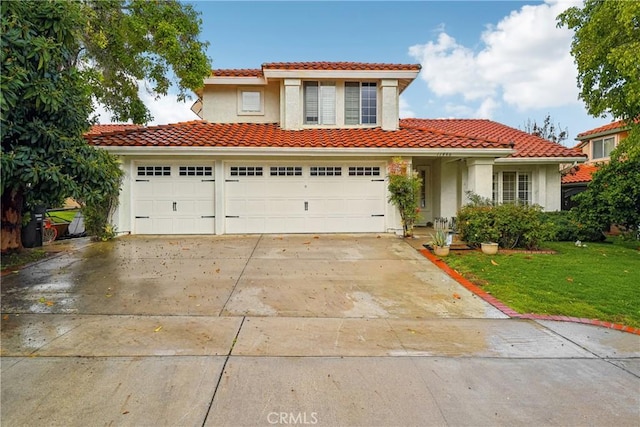 mediterranean / spanish home with stucco siding, a tiled roof, driveway, and a front lawn