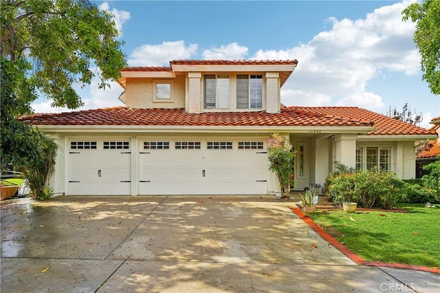 mediterranean / spanish-style house with stucco siding, concrete driveway, and a tiled roof