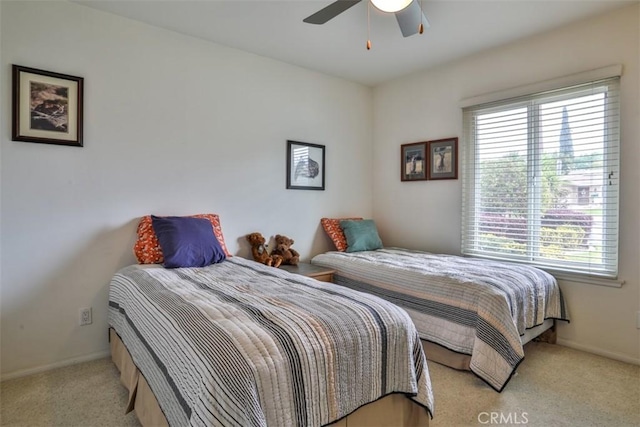 bedroom with ceiling fan, baseboards, and light carpet