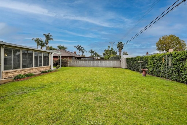 view of yard with a fenced backyard and a sunroom