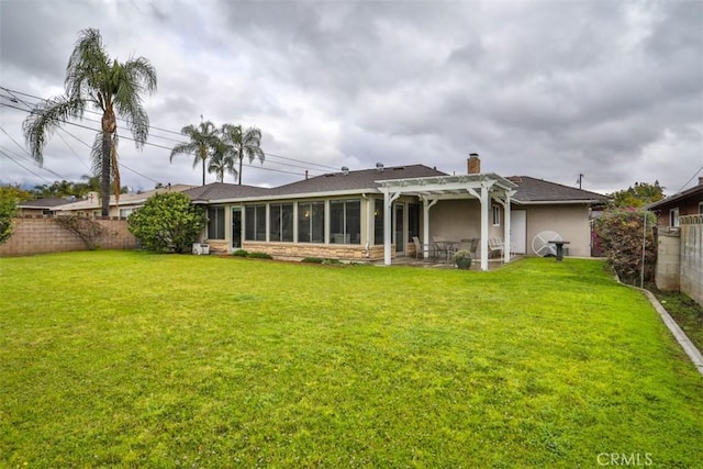 back of property featuring a sunroom, a chimney, a yard, a fenced backyard, and a pergola