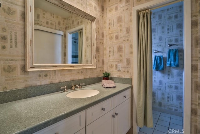 bathroom featuring tile patterned flooring, wallpapered walls, and vanity