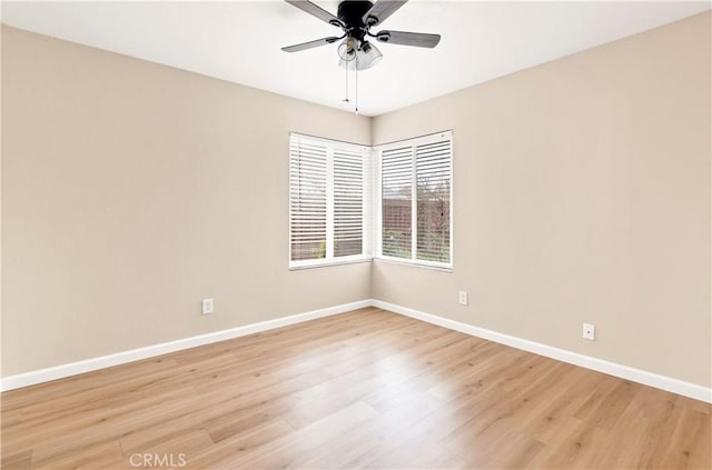 unfurnished room featuring baseboards, light wood-style floors, and a ceiling fan