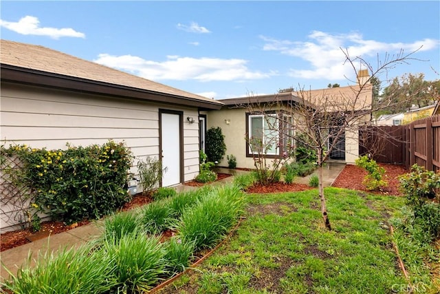 rear view of property featuring a yard and fence