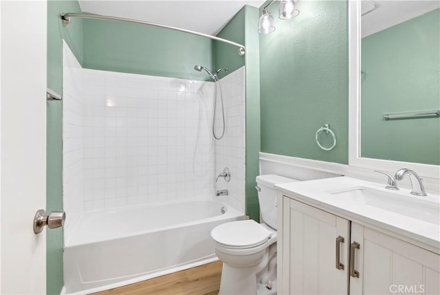 bathroom with bathtub / shower combination, toilet, wood finished floors, and vanity