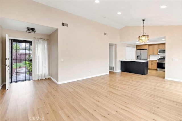 unfurnished living room with lofted ceiling, baseboards, visible vents, and light wood finished floors