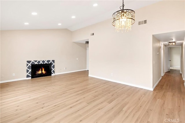 unfurnished living room with vaulted ceiling, light wood-style flooring, baseboards, and visible vents