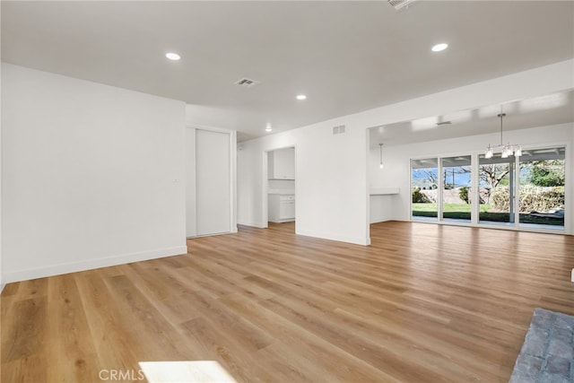 unfurnished living room with recessed lighting, visible vents, light wood finished floors, and baseboards