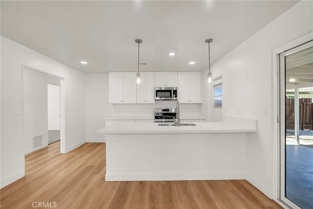 kitchen with visible vents, light wood finished floors, appliances with stainless steel finishes, and light countertops